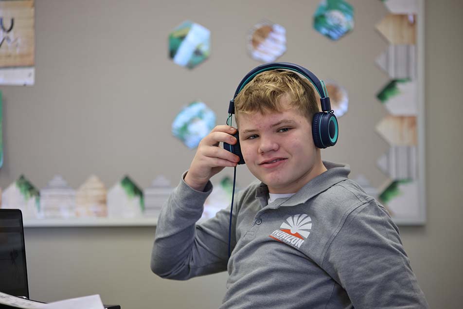 student in classroom smiling at camera